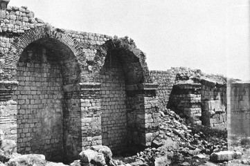 Ruine mit zwei erhaltenen Rundbögen und Trümmerfeld