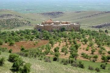 Kloster in weiter Landschaft mit Olivenhainen und Feldern