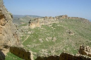Felswand mit Mauerresten oberhalb eines Tals